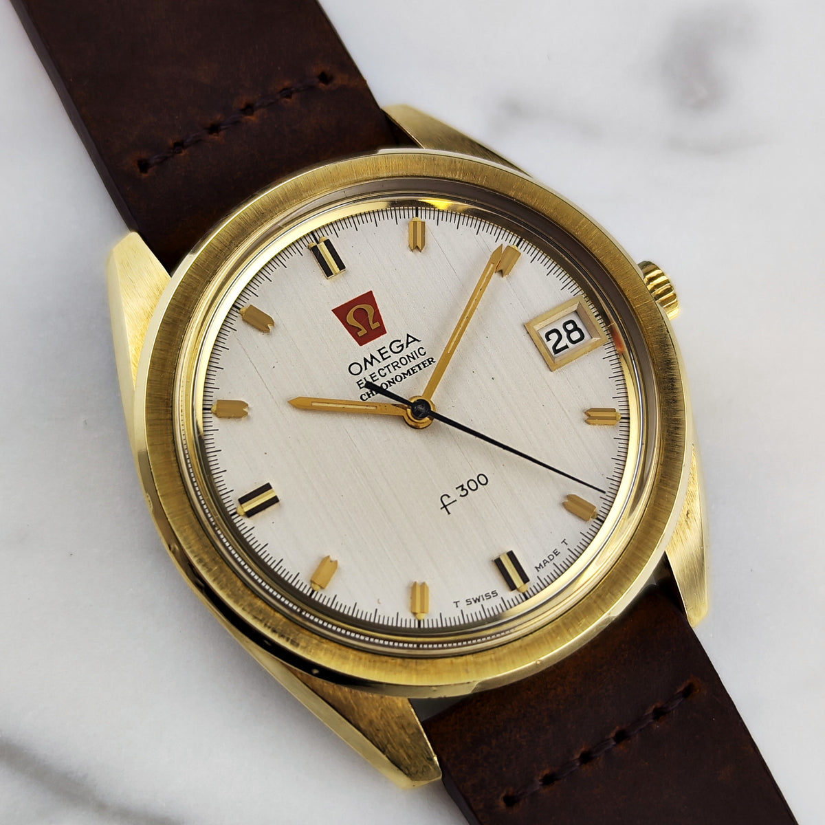 Omega Chronometer f300Hz Gold White Dial 1970 – Vorderansicht am Marmorhintergrund
